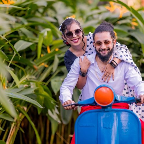 Couple riding a colourful scooter during a fun pre-wedding photoshoot